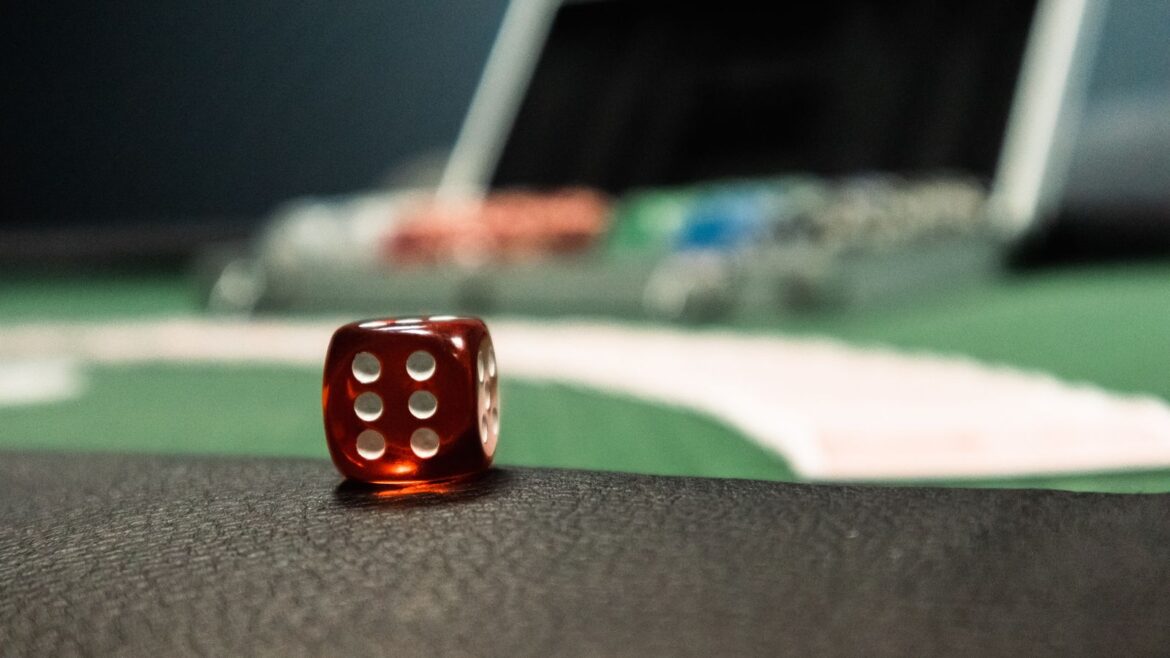 Dé rouge en gros plan sur une table de casino, jeux via bot Telegram