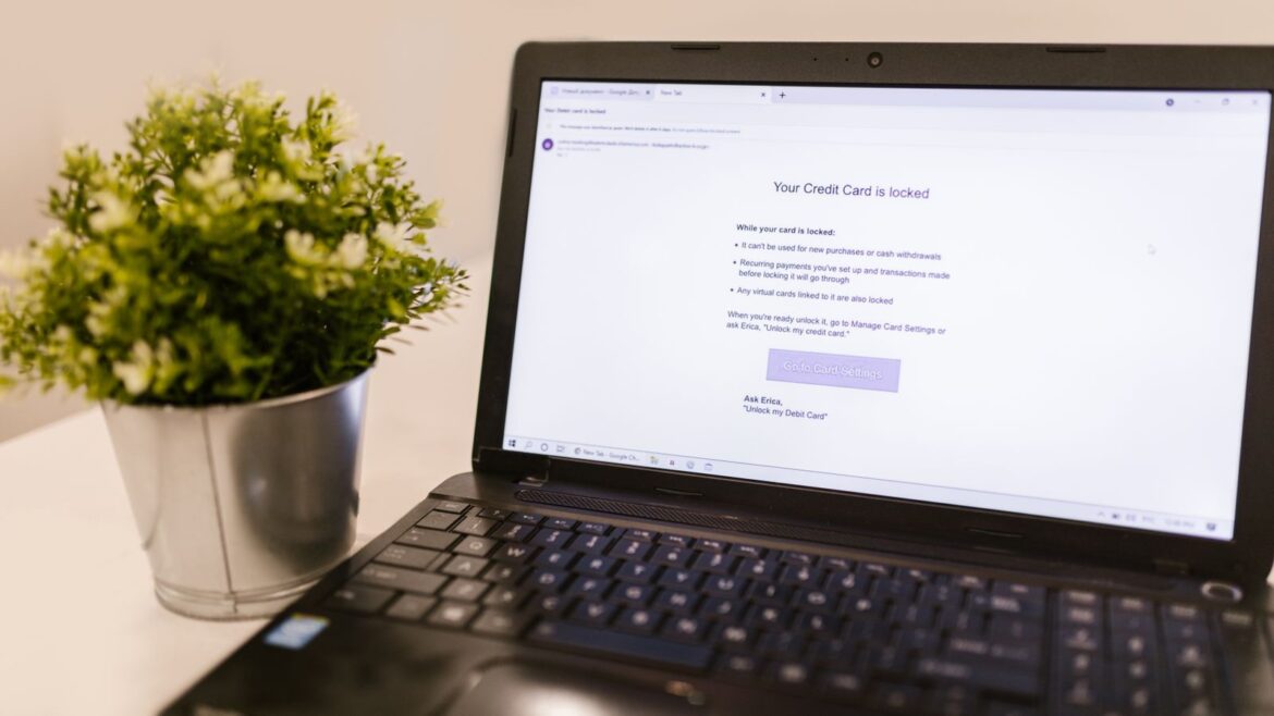 Écran d'ordinateur portable affichant une notification de sécurité bancaire près d'une plante