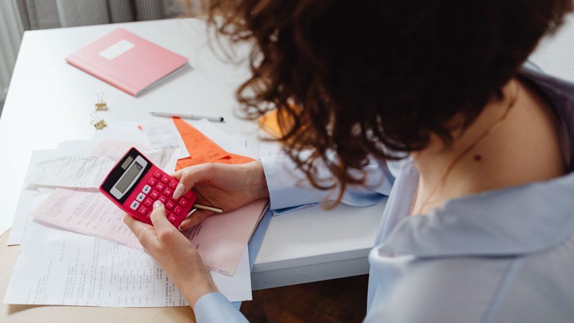 Femme calculant des dépenses avec documents et calculatrice pour jouer responsable