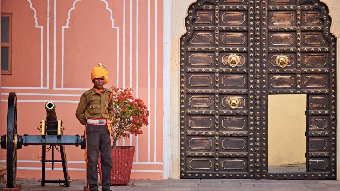 Garde en tenue traditionnelle près d'une porte ornée et d'un canon, sécurité