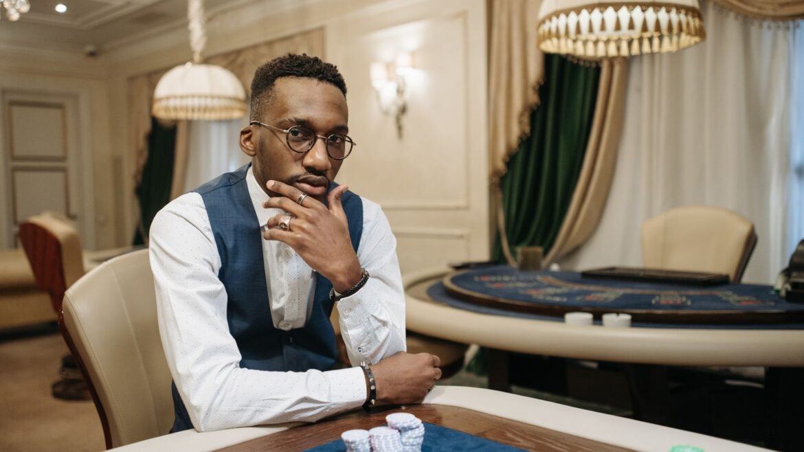 Homme assis à une table de casino, jetons de poker, position de jeu concentrée