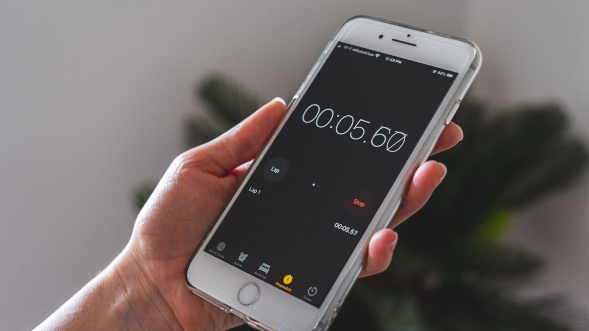 Main tenant un smartphone avec un chronomètre actif, pour limiter le temps de jeu