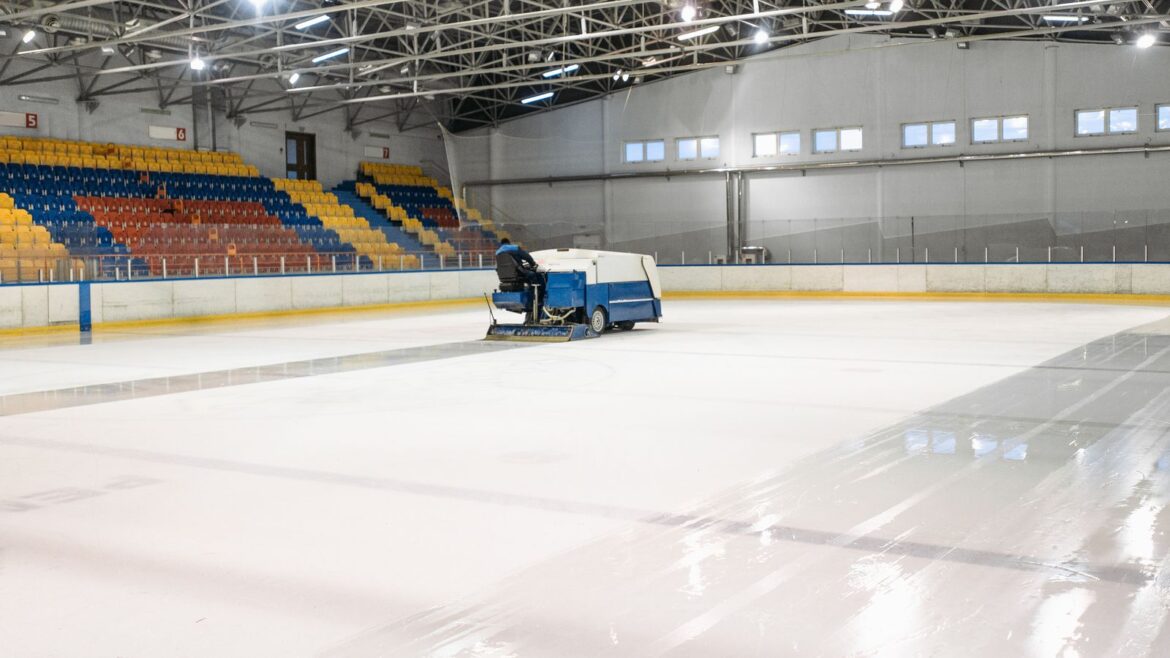 Une resurfaceuse à glace lisse la piste d'une patinoire intérieure